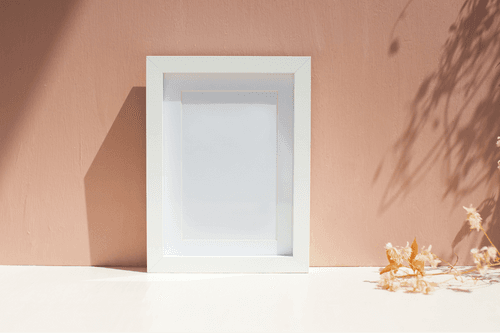 White Frame Mockup Against Wall
